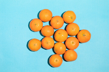 Juicy and healthy mandarins, messy, on a blue background, forming a pop art style image
