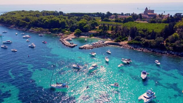 Flying around the port of Saint Honorat island part of the Iles de L&eacute;rins, next to Cannes in south of France. Clear watter of the mediterranean sea, little boats, wineyards and monastery on the island
