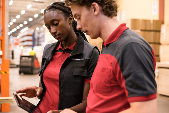 Male and female sales staff using digital tablet at hardware store