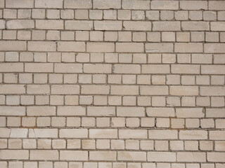View of empty, white brick wall background with copy space. A deteriorating brick wall outdoors in sunlight