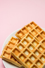 Homemade waffles on a pink background. Tasty breakfast