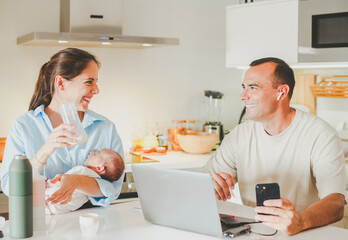 Obraz premium Happy family with baby and working in kitchen