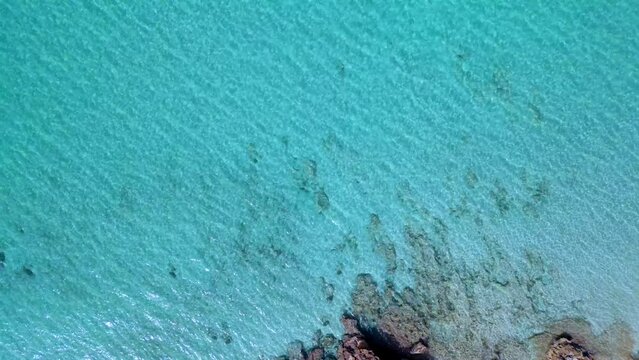 rocks in crystal clear caribbean water. Dramatic aerial view flight Formentera