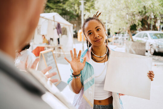 Female customer bargaining while holding record at flea market
