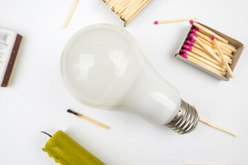 Candle with light bulb and matches on white