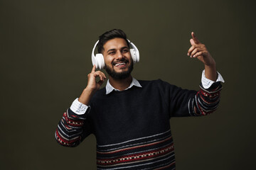 Happy smiling indian man in wireless headphones gesturing isolated