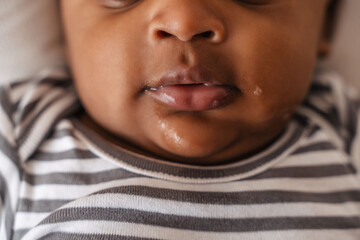 Close-up mouth of cute african baby making slobber - obrazy, fototapety, plakaty