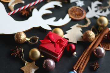 Small presents, various Christmas ornaments and deer figurine on dark background. Selective focus.