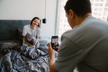 White young man taking photo of his girlfriends on mobile phone