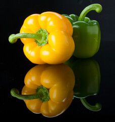 Yellow and green paprika on black acrylic glass.