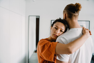 Young white couple hugging together in bedroom at home