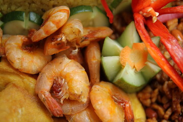 Close up photo of Fried shrimp, tofu, dried tempeh, cucumber as a side dish of Nasi Tumpeng (Tumpeng rice)