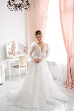 beautiful bride in an expensive wedding dress in full growth posing in a bright interior