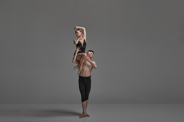 Young man and woman, ballet dancers performing isolated over dark grey studio background. Sitting on a shoulder © master1305