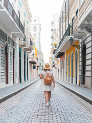 Young woman portrait walking with white dress through a city hall of spanish buildings from puerto rico san juan