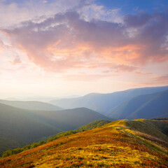 Fototapeta na wymiar mountain chain silhouette in blue mist at the sunset, early morning mountain travel scene