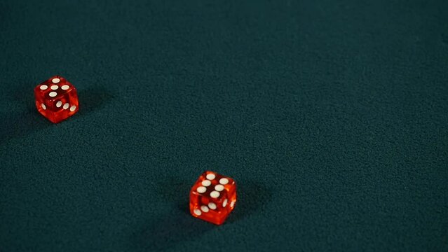 Casino player rolls eleven in craps, rolling five and six with pair of red dice on green casino gaming table, Slow motion