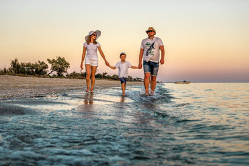 Family walking by the sunset beach