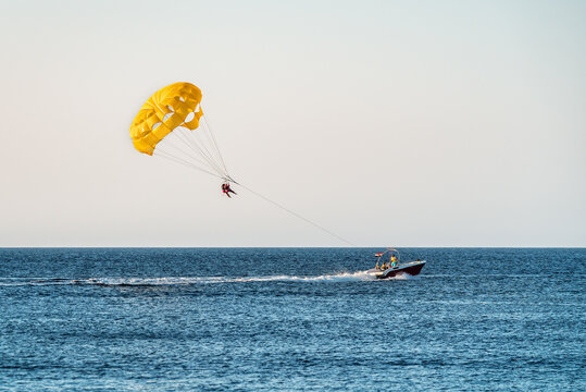 Parasailing by boat water amusement. Flying on a parachute behind a boat on a summer holiday