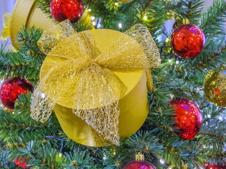 Christmas tree decoration in the form of a beautiful gift box with a golden bow