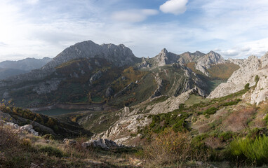 Beautiful panoramic view of the mountains, rocks, its vegetation and beautiful orange trees in the fall in the Valle de Anciles, León, Spain