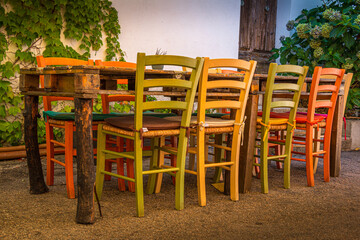 Fototapeta na wymiar self made table with colored chairs in sardinia, italy 