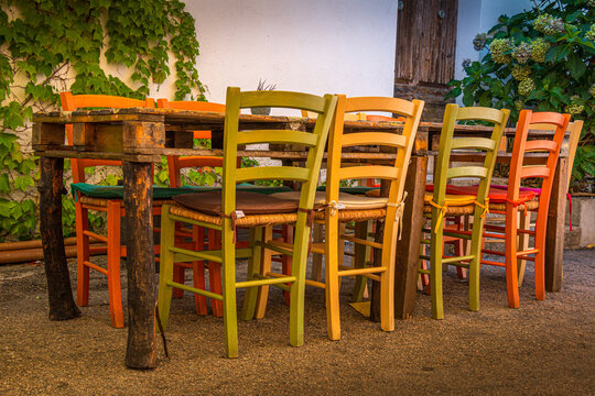 self made table with colored chairs in sardinia, italy 