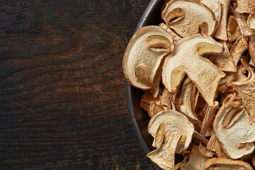 Dried white mushrooms on a dark background. Flat lay. Copy space