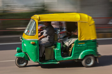 Indian auto (autorickshaw) taxi in the street. Motion blur. Delhi, India - 545189886