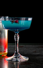 Blue lagoon cocktail with blue curacao liqueur, vodka, lime juice and soda on table