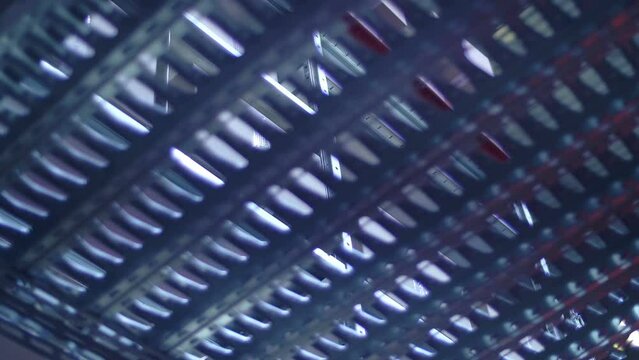 New perforated metal shelves for racks in a large warehouse, a beam of light penetrates through the holes. Shot in motion. Closeup