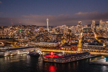 Seattle, Washington, USA - November 2022, night aerial view of illuminated Seattle Downtown and the Waterfront pier area with famous Space Needle Tower - aerial night view  	