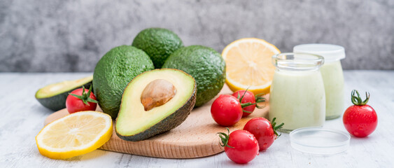 Avocado yogurt and various fruits on a cutting board