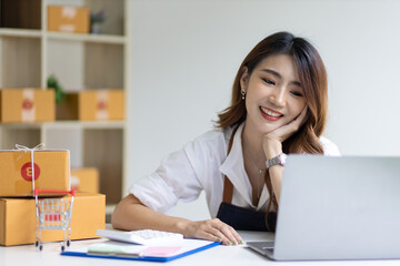 Portrait of Asian young woman SME working with a box at home the workplace.start-up small business owner, small business entrepreneur SME or freelance business online and delivery concept.