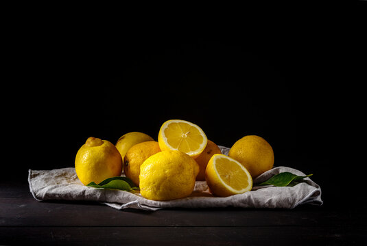 Citrus, lemon, fruits on wooden table. Dark light. Front view.  Copy space