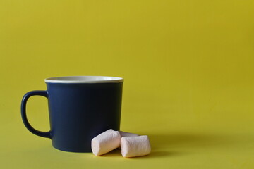 blue mug, pink marshmallow, yellow background
