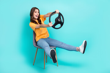 Full length photo of excited funny lady wear yellow t-shirt driving car looking empty space sitting...