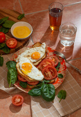 Sandwiches with cheese sauce, spinach, tomatoes and fried eggs. Close up