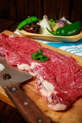 Raw pork with vegetables and spices on wooden board, vertical shot