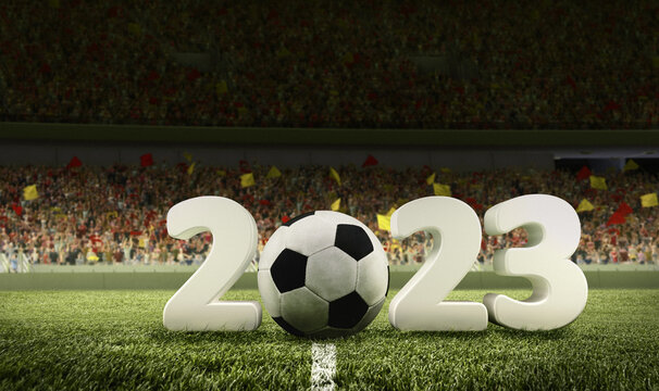 Traditional soccer football ball on grass of football field between huge numbers 2023 at crowded stadium with spotlight. Concept of sport, art, energy, power