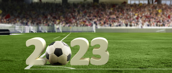 Traditional soccer football ball on grass of football field between huge numbers 2023 at crowded...