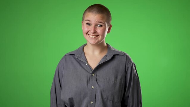 Smiling young gender fluid woman 20s years old posing isolated on green screen chroma key background studio. People sincere emotions lifestyle concept. Looking at camera with charming smile