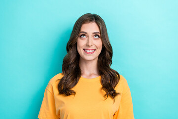 Fototapeta premium Photo of cute nice pleasant girl with wavy hairstyle wear yellow t-shirt curious look empty space isolated on turquoise color background