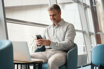 Middle-aged male employee is uses modern devices