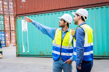 Two male engineers in a container shipping company Consulting to check the order for the container that is responsible