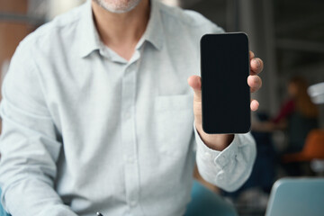Man in casual clothes holds a phone in his hand