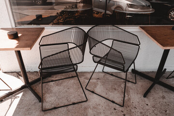 original metal wire chairs and wooden tables outside a quiet coffee shop ,George cafe, New Zealand