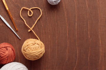 Obraz na płótnie Canvas Heart Shaped cotton thread and yarn balls for Crocheting Handmade on a Light Colored Wooden background