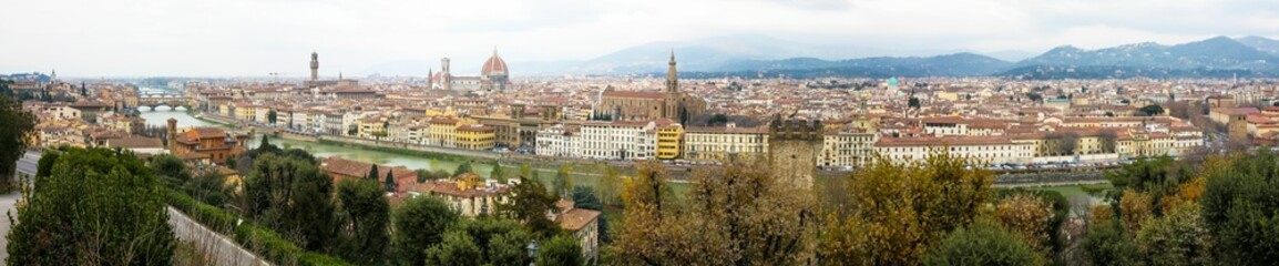 Fototapeta na wymiar Panoramic urban scenery of Florence with a cloudy sky and foggy mountains background, Italy