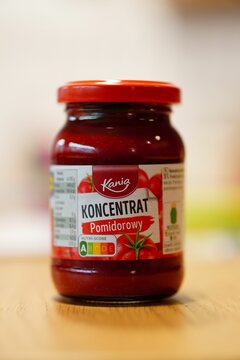 Vertical shot of Polish Kania brand tomato puree in a glass jar on a table